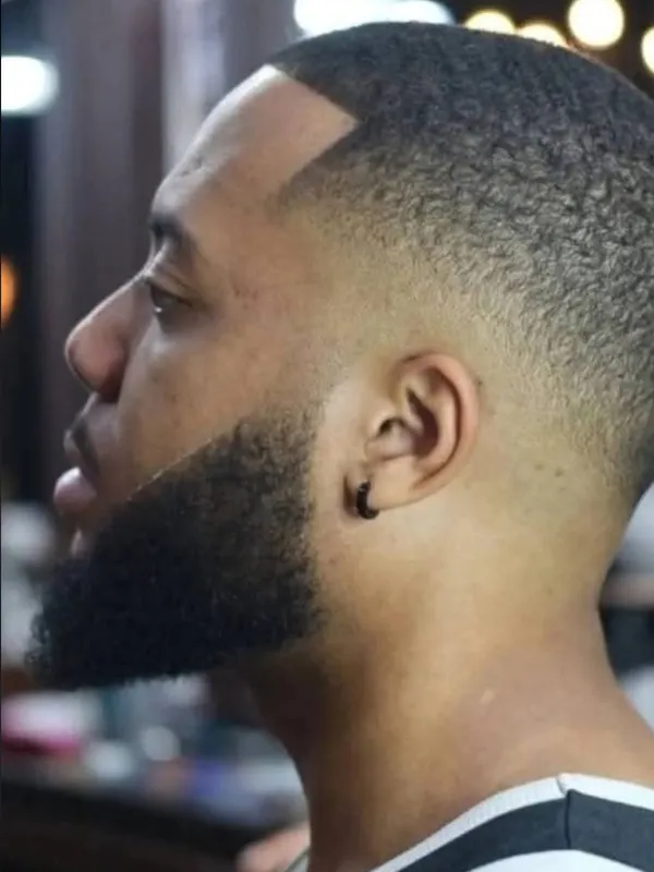 Low taper with a sharp line up and beard