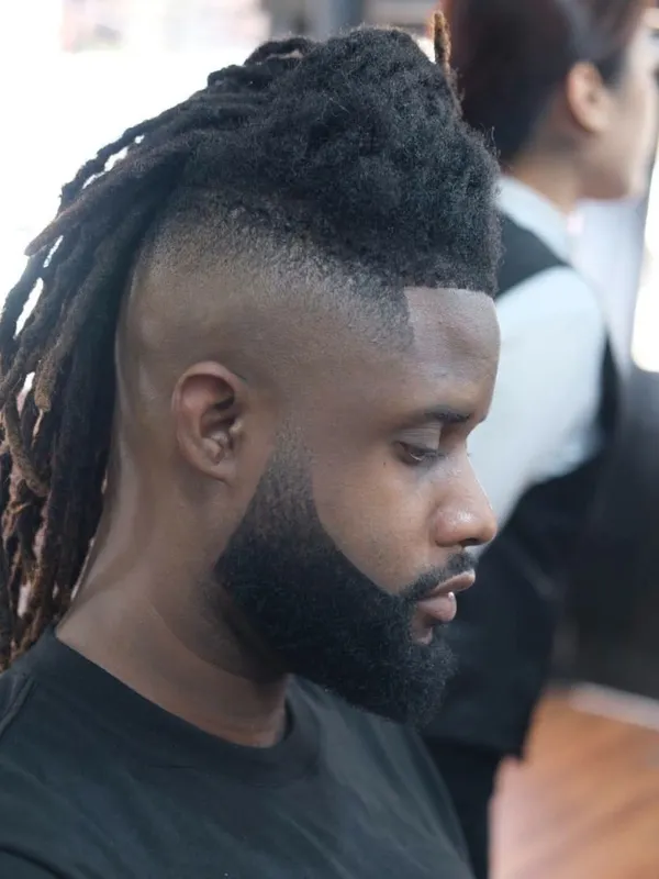 Locs with a high skin fade and beard
