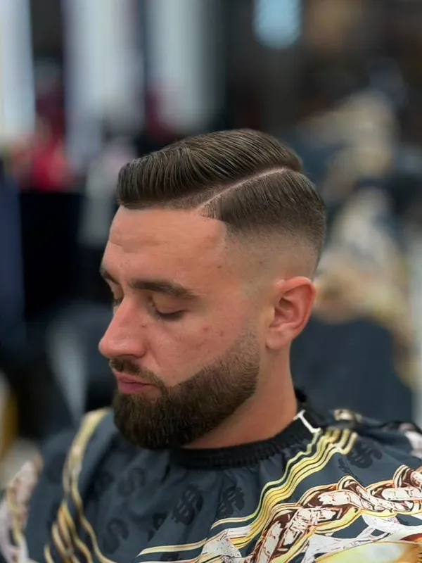 Combed side part with a beard fade