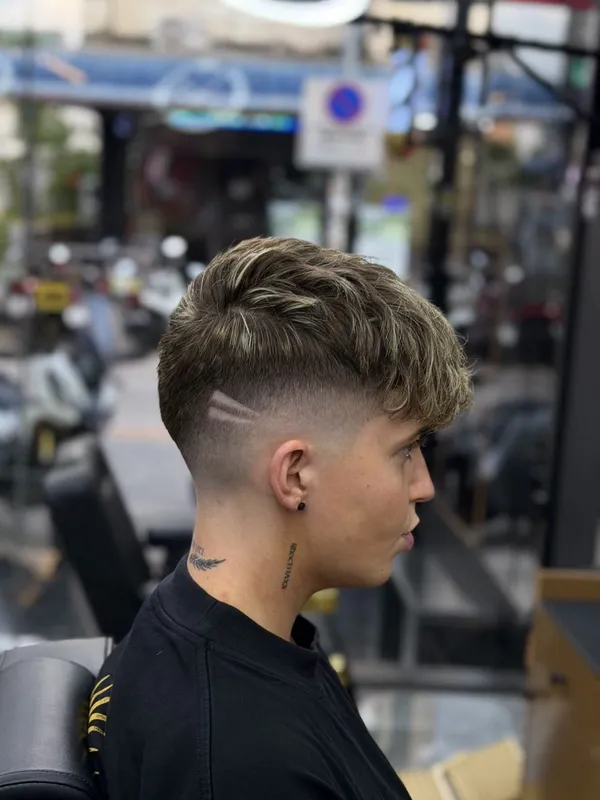 Mid fade with a combed side part and full beard