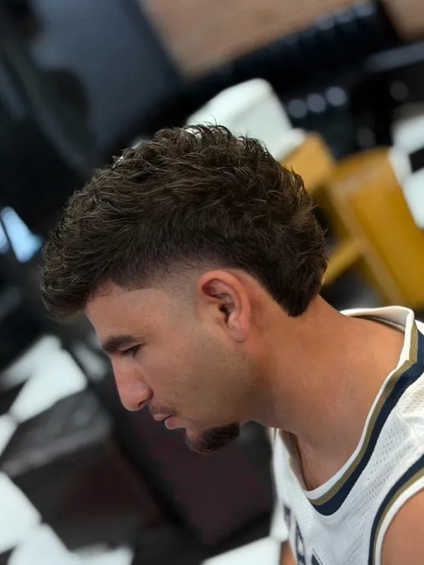 Curly top with a taper fade, side view