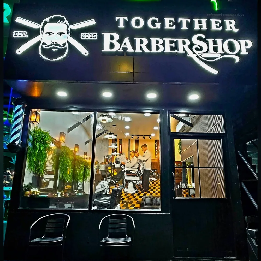 Jomtien Second Road branch with a lit Together Barbershop sign at night